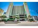 Multi-story building showcasing balconies and tropical landscaping enhancing its curb appeal at 5310 N Ocean Blvd. # 10B, North Myrtle Beach, SC 29582