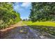A long, secluded driveway leads to a charming home with a lush green lawn, framed by mature trees at 5589 Highway 668, Conway, SC 29526