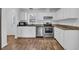 Bright, well-lit kitchen with white cabinets, stainless steel appliances, and modern granite countertops at 5589 Highway 668, Conway, SC 29526