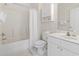 Bright bathroom featuring a tub-shower combo, white vanity, and floral wallpaper at 5750 Oyster Catcher Dr. # 822, North Myrtle Beach, SC 29582