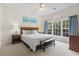 Serene bedroom with large windows, beach themed artwork, and a cozy bench at 5750 Oyster Catcher Dr. # 822, North Myrtle Beach, SC 29582