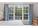 Bedroom featuring a beautiful window with palm tree views and stylish blue striped curtains at 5750 Oyster Catcher Dr. # 822, North Myrtle Beach, SC 29582