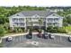A three-story condo building with white railings and palm trees in front of the parking area at 5801 Oyster Catcher Dr. # 332, North Myrtle Beach, SC 29582