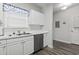 Well-lit kitchen with white cabinets, stainless steel dishwasher, and a double basin sink at 5801 Oyster Catcher Dr. # 332, North Myrtle Beach, SC 29582