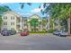 Inviting condominium complex with yellow siding, white trim, palm trees, and ample parking at 601 N Hillside Dr. # 4434, North Myrtle Beach, SC 29582