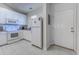 Well-lit kitchen featuring white appliances and cabinetry and tile flooring near a door at 601 N Hillside Dr. # 4434, North Myrtle Beach, SC 29582