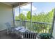 Relaxing screened balcony with seating and lush green views, offering a serene outdoor space to unwind and enjoy nature at 6203 Catalina Dr. # 1333, North Myrtle Beach, SC 29582