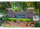 A welcoming community entrance sign with brick pillars, patriotic decor, and vibrant floral landscaping at 6203 Catalina Dr. # 1333, North Myrtle Beach, SC 29582
