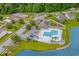 Aerial view of neighborhood amenities including pool, tennis courts, and playground by lake at 675 Vermillion Dr., Little River, SC 29566