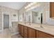 Well-lit bathroom featuring double sinks, a large mirror, and neutral decor at 675 Vermillion Dr., Little River, SC 29566