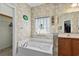 Bright bathroom features a jetted tub, patterned wallpaper, and ample counter space with modern fixtures at 675 Vermillion Dr., Little River, SC 29566