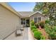 Inviting front porch with seating and a lovely garden featuring lush greenery and colorful flowers around the home's entrance at 675 Vermillion Dr., Little River, SC 29566