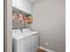 Well-equipped laundry room featuring a washer, dryer, overhead cabinets, and shelving at 675 Vermillion Dr., Little River, SC 29566