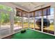 Bright sun room featuring many windows, a ceiling fan, and green carpet at 675 Vermillion Dr., Little River, SC 29566