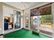 Cozy sun room offers many windows, lake views, a ceiling fan, and green carpet at 675 Vermillion Dr., Little River, SC 29566