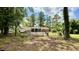 Rear view of house with a wooden deck surrounded by a chain link fence in a large wooded lot at 6805 Mclaurin Rd., Mullins, SC 29574