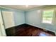 Bedroom features a door, hardwood flooring, and natural light from a window at 6805 Mclaurin Rd., Mullins, SC 29574