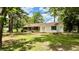Inviting home with a brick facade and white siding, framed by mature trees and a sunny sky at 6805 Mclaurin Rd., Mullins, SC 29574