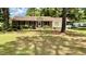 Charming brick home featuring a well-maintained lawn, complemented by mature trees and classic black shutters at 6805 Mclaurin Rd., Mullins, SC 29574