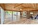 Sun room with wood floors and ceiling, brick accent wall, and surrounded by windows at 6805 Mclaurin Rd., Mullins, SC 29574