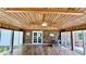 Sun room with wood floors and ceiling, brick accent wall, and surrounded by windows at 6805 Mclaurin Rd., Mullins, SC 29574