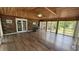 Sun room with wood floors and ceiling, brick accent wall, and surrounded by windows at 6805 Mclaurin Rd., Mullins, SC 29574