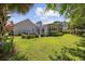 Well-manicured backyard with a patio, sunroom, and lush landscaping and a green lawn at 7005 Wellesley Ct., Murrells Inlet, SC 29576