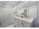 Bathroom featuring double sinks, white cabinets, a large mirror, and a walk-in shower with glass door at 7005 Wellesley Ct., Murrells Inlet, SC 29576