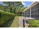 View of a sunroom patio with brick pavers, a table, a hedge, and a manicured lawn at 7005 Wellesley Ct., Murrells Inlet, SC 29576