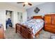 Bedroom with wood furnishings, ceiling fan, and connecting ensuite bathroom and closet at 701 Salleyport Dr. # 1110, Myrtle Beach, SC 29579