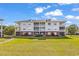 Multi-story condominium with balconies surrounded by a lush green lawn and mature landscaping at 701 Salleyport Dr. # 1110, Myrtle Beach, SC 29579