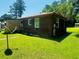 The backyard features a brick exterior, green lawn, and satellite dish at 704 W Alder St., Andrews, SC 29510