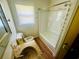 Compact bathroom features vanity, mirror, shower-tub combo, and a window at 704 W Alder St., Andrews, SC 29510