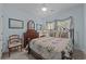 Charming bedroom features an iron bed frame, floral bedding, and coordinating dresser with a mirror at 77 Redwing Ct., Pawleys Island, SC 29585