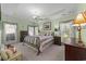 Spacious bedroom with tray ceiling, two dressers, and large windows with elegant drapes at 77 Redwing Ct., Pawleys Island, SC 29585