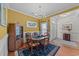 Inviting dining room showcasing warm yellow walls, wainscotting, hardwood floors, and a view into the entryway at 77 Redwing Ct., Pawleys Island, SC 29585