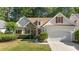 Charming single-Gathering home featuring a stone accent wall, red shutters, well-manicured lawn and two-car garage at 77 Redwing Ct., Pawleys Island, SC 29585