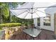 An outdoor patio featuring a dining table with umbrella and a stone retaining wall at 77 Redwing Ct., Pawleys Island, SC 29585