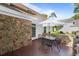 Outdoor patio with stone wall, table with four chairs, and well-maintained landscaping at 77 Redwing Ct., Pawleys Island, SC 29585