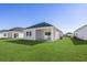 Spacious backyard with green grass and a covered patio area at 8253 Vibrant Loop, Longs, SC 29568