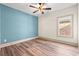Inviting bedroom with a blue accent wall, ceiling fan, and warm wood flooring at 873 Crystal Water Way, Myrtle Beach, SC 29579