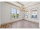 Bright dining room with wood floors, elegant light fixture, and large windows overlooking the landscape at 873 Crystal Water Way, Myrtle Beach, SC 29579