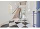 This foyer boasts a beautiful staircase, black-and-white tile, and natural light at 873 Crystal Water Way, Myrtle Beach, SC 29579