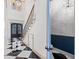 This foyer boasts a beautiful staircase, black-and-white tile, and natural light at 873 Crystal Water Way, Myrtle Beach, SC 29579