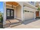 Inviting front entrance featuring a dark wooden door with sidelights, overhead lighting, and a two-car garage at 873 Crystal Water Way, Myrtle Beach, SC 29579