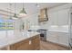 Gourmet kitchen with a large marble island, stainless steel appliances, and custom range hood at 873 Crystal Water Way, Myrtle Beach, SC 29579