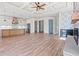 Open-concept living room with fireplace, coffered ceilings, wood floors, and a built in bar at 873 Crystal Water Way, Myrtle Beach, SC 29579