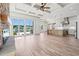 Open-concept living room featuring stone fireplace, coffered ceilings, wood floors, and waterfront views at 873 Crystal Water Way, Myrtle Beach, SC 29579