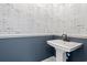 This blue powder room features black faucet, newspaper wallpaper, and pedestal sink at 873 Crystal Water Way, Myrtle Beach, SC 29579