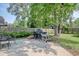 Backyard featuring a patio with a grill and other outdoor cooking equipment, surrounded by trees and a fence at 900 47Th Ave. N, Myrtle Beach, SC 29577